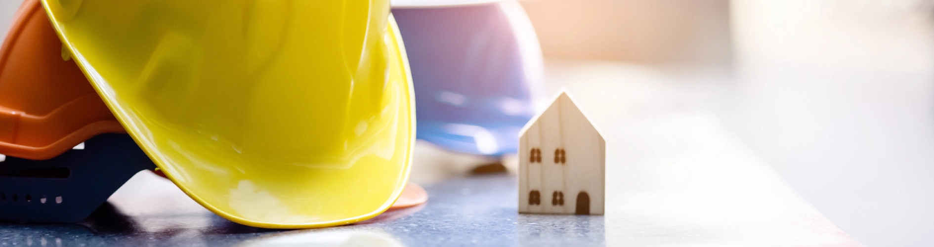 żółty kask i drewniany domek